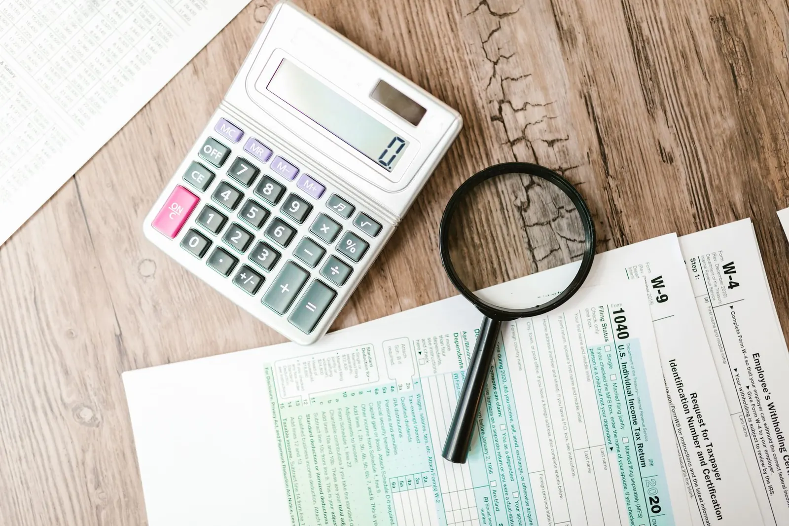Tax forms, calculator and magnifying glass