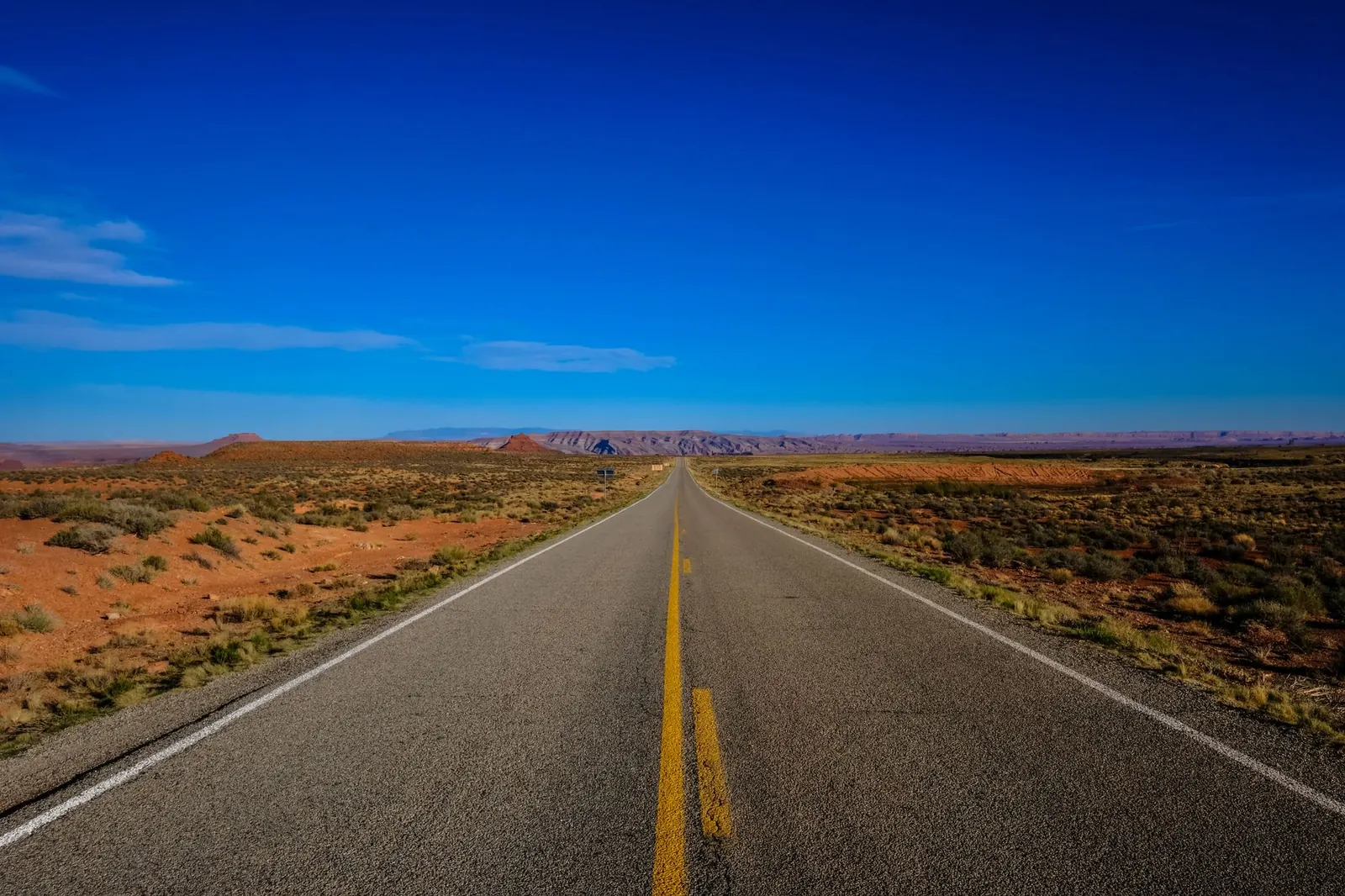 Straight desert highway under a blue sky