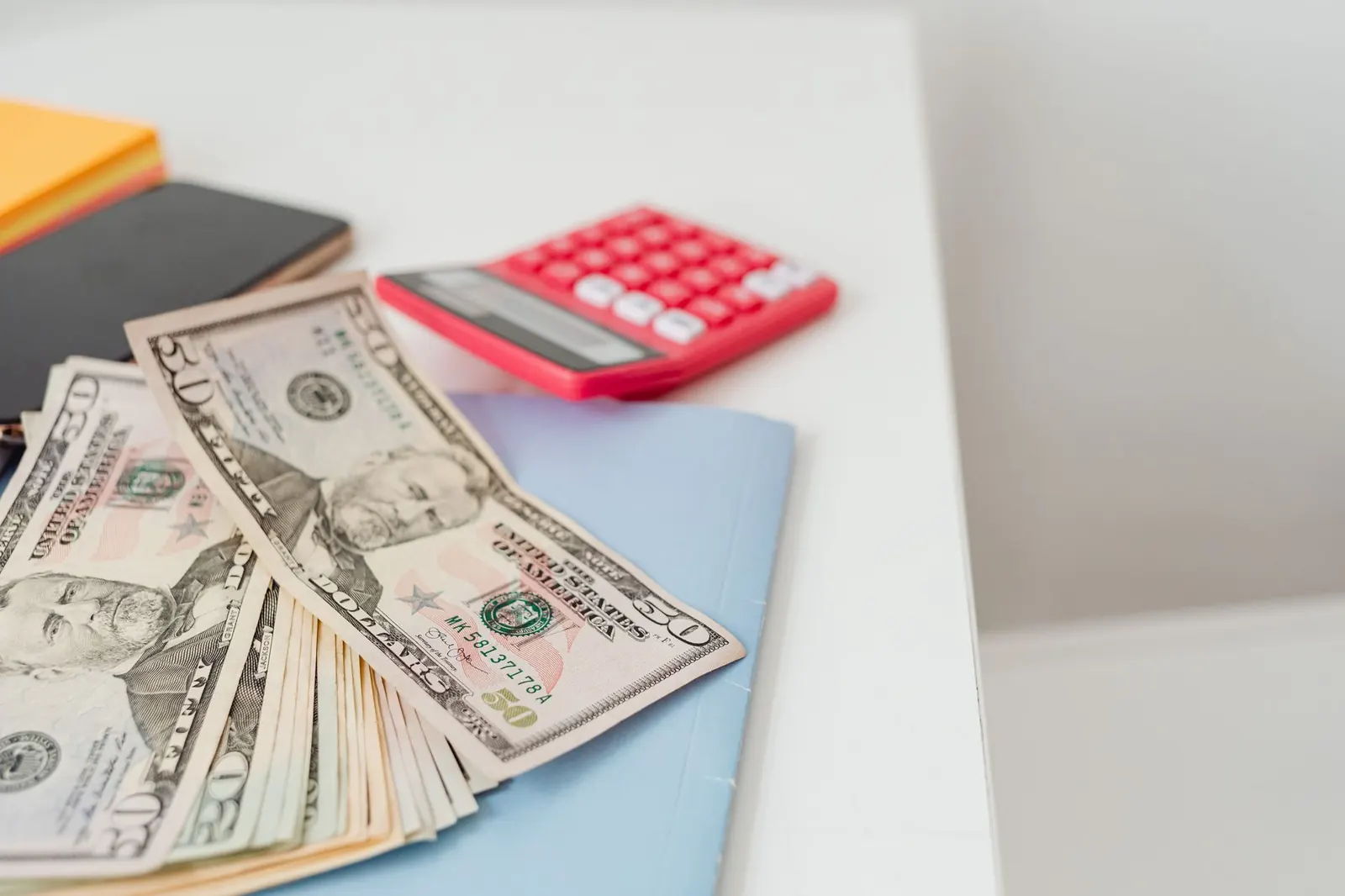 Calculator, cash and folders on a desk