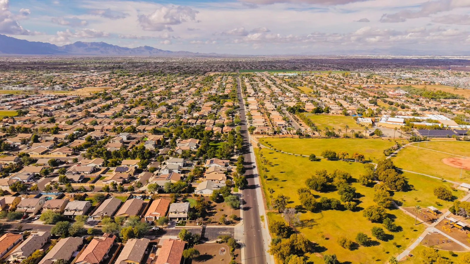 Aerial view of Phoenix neighborhoods with mountains on the horizon